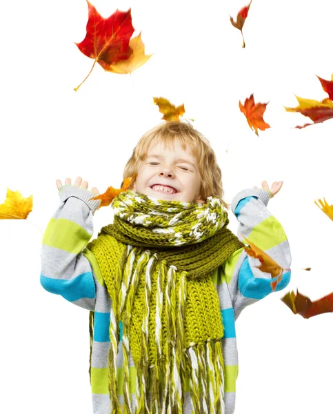 Ребенок в шерстяном шарфе играет с кленовыми листьями — стоковое фото