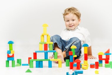 Child playing toys blocks over white clipart