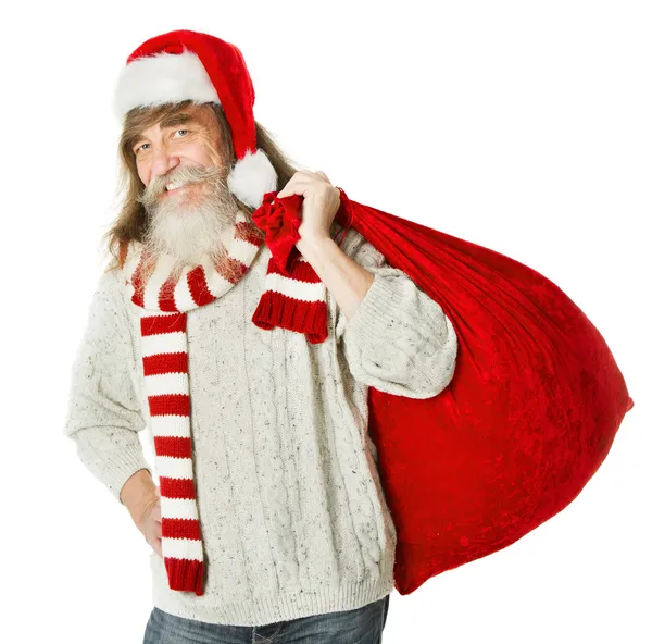 Christmas old man with beard in red hat carrying Santa Claus bag — Stock Photo, Image