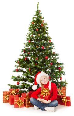 Christmas Child in Santa hat sitting under Xmas Tree, White