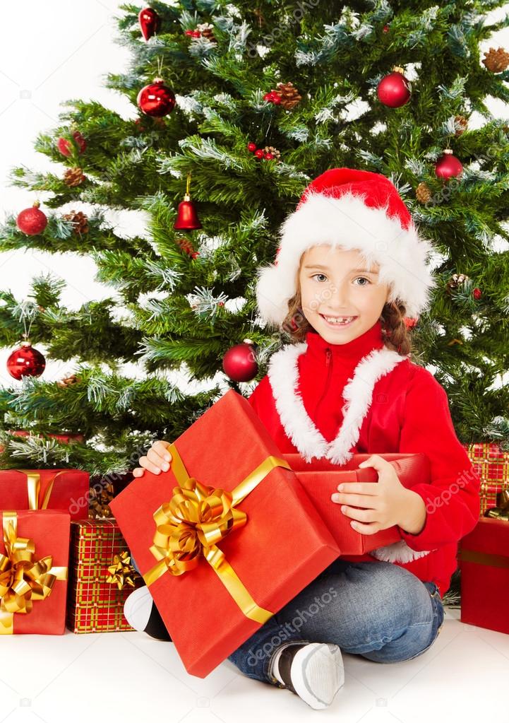Christmas child open gift box, sitting under fir tree
