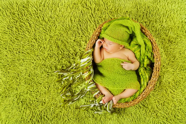 Bebê recém-nascido dormindo em chapéu de lã sobre tapete verde — Fotografia de Stock