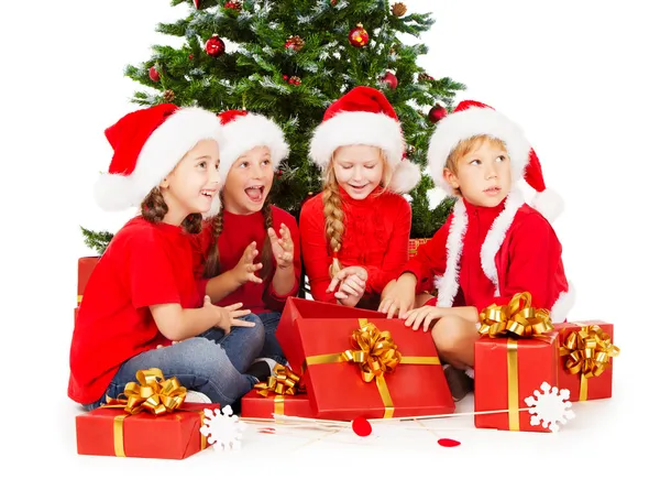 Рождественские дети в шляпе Санты с подарками — стоковое фото