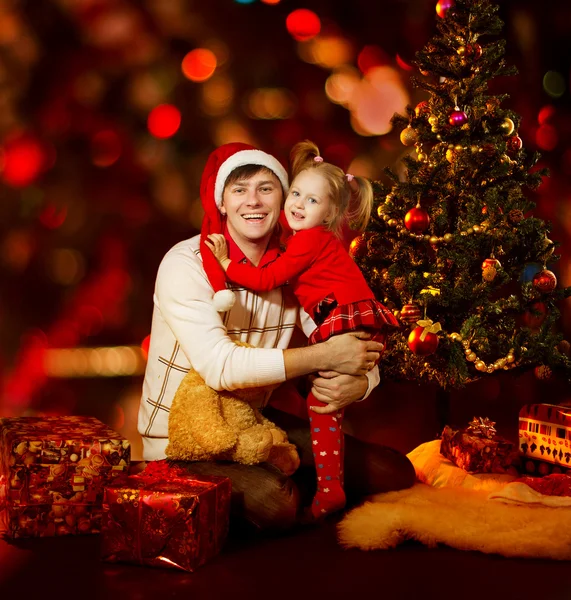 Christmas family. Father and Daughter Kid under Xmas tree, red — Stock fotografie