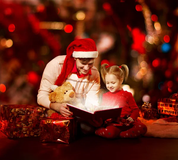 Boże Narodzenie rodzinne czytanie książki. Ojciec i dziecko otwarcie magiczne bajki tal — Zdjęcie stockowe