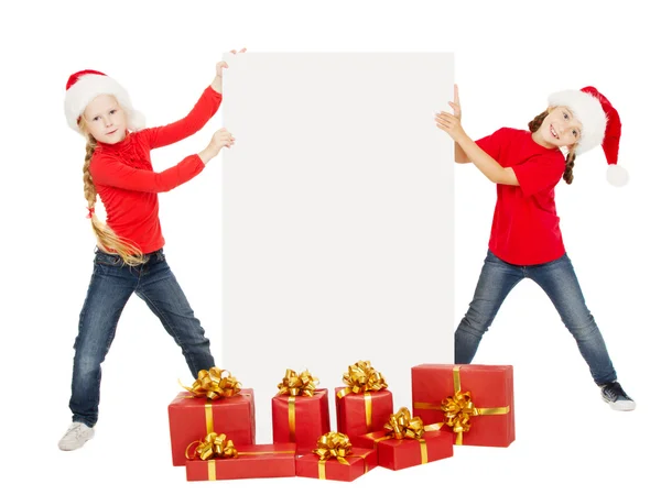 Feliz Navidad niños sosteniendo la pancarta. Ayudantes de Santa en gorras con —  Fotos de Stock