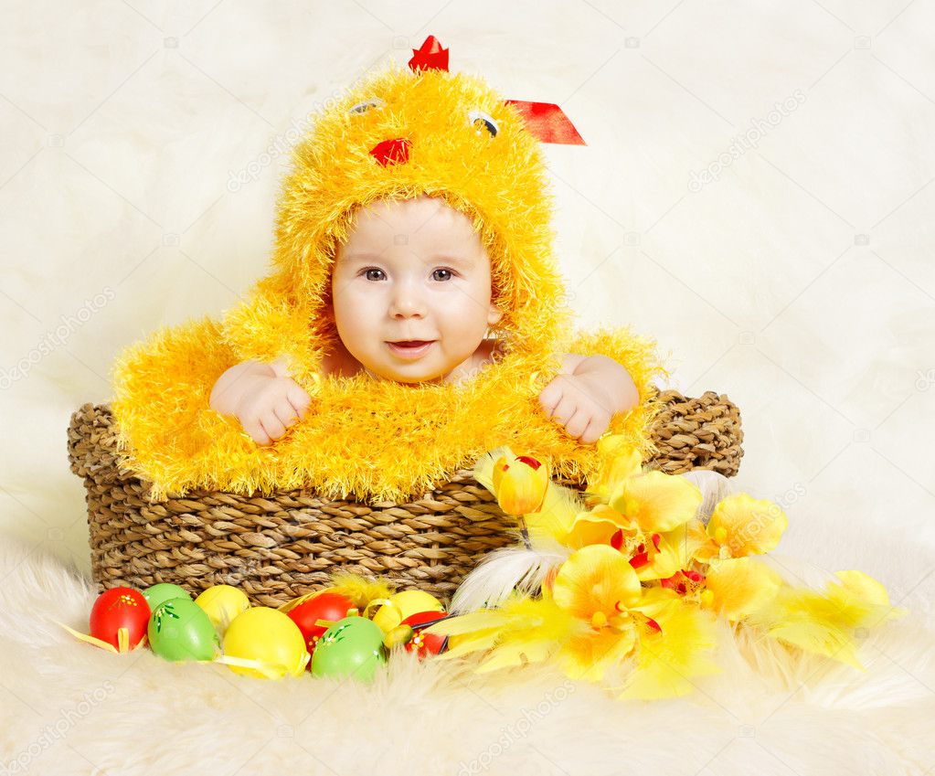 Baby in Easter basket with eggs in chicken costume. Easter holiday concept: nest with baby chick