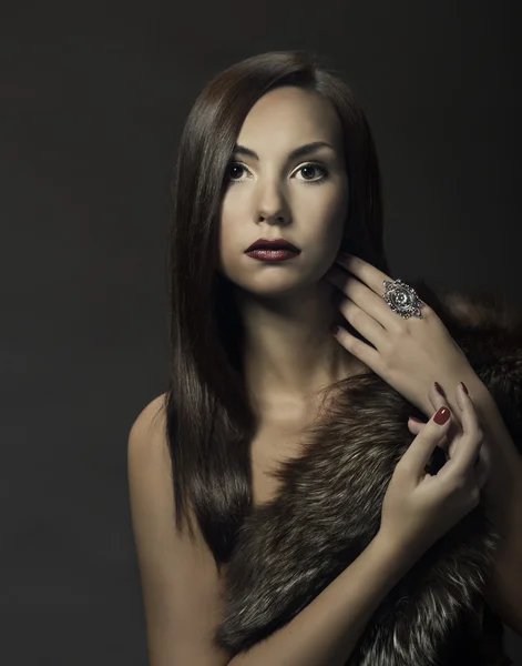 Retrato de beleza de mulher em casaco de pele de luxo. Menina bonita no fundo escuro — Fotografia de Stock