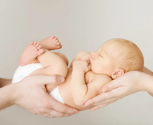 Bebê recém-nascido dormindo nas mãos dos pais, recém-nascido criança e família — Fotografia de Stock