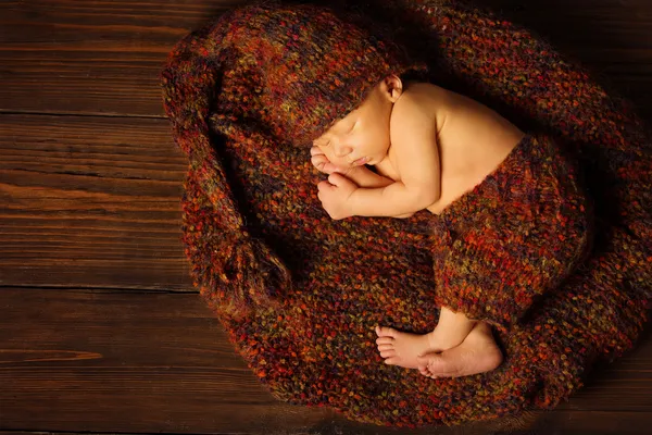 Bambino neonato ritratto, bambino che dorme in cappello di lana su sfondo di legno marrone — Foto Stock