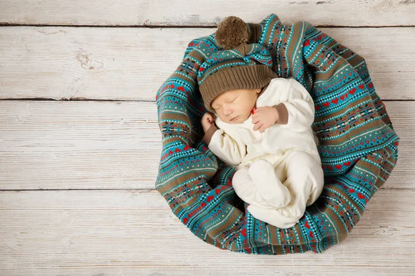 Bebé recién nacido durmiendo en sombrero de lana sobre fondo de madera blanca, cálido estilo país de invierno —  Fotos de Stock