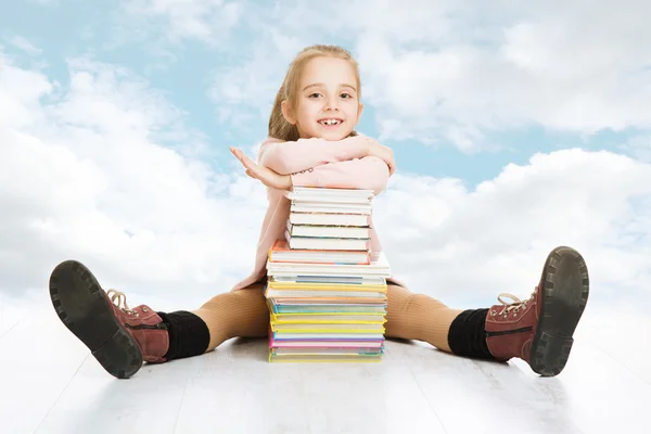 Iskola lány és könyvek stack. mosolyogva ült át kék felhős ég, boldog gyermek tanuló. — Stock Fotó