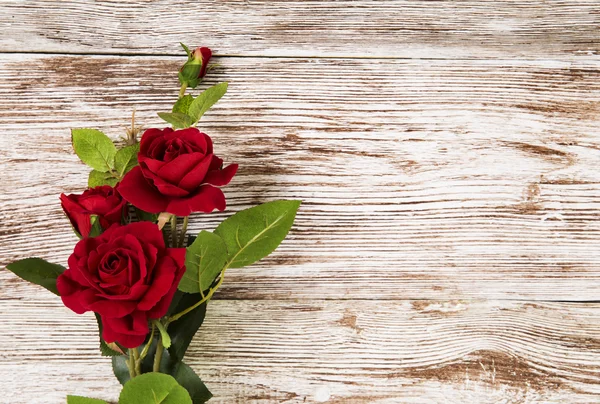 Rosa flores, rojo sobre fondo grunge de madera, espacio de copia de la tarjeta floral — Foto de Stock