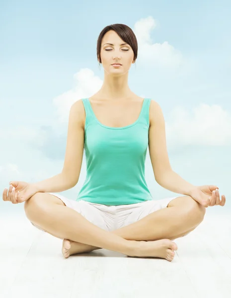 空を背景にロータスのポーズで座っている女性ヨガ瞑想します。. — ストック写真