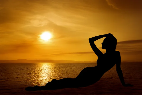 Deniz üzerinde gökyüzü günbatımı üzerinde kadın seksi siluet — Stok fotoğraf
