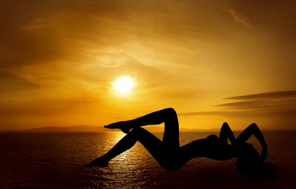 Donna silhouette sexy sopra il cielo tramonto sul mare — Foto Stock