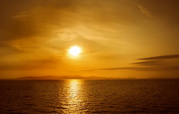 Sunset on sea. Bright sun on sky. Orange beach landscape