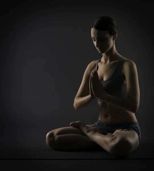 Γυναίκα γιόγκα, meditate κάθεται στο λωτό παρουσιάζουν. σιλουέτα του κορίτσι άσκηση πάνω από το μαύρο φόντο — Φωτογραφία Αρχείου