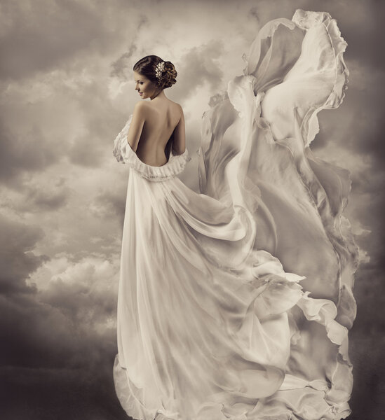 Woman portrait in retro dress, artistic white blowing gown, waving and fluttering fabric, fantasy wedding bride