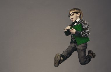 Çocuk koşarak geri okula, komik çocuk portre, gözlük ve kitap ile akıllı okul çocuğu atlama