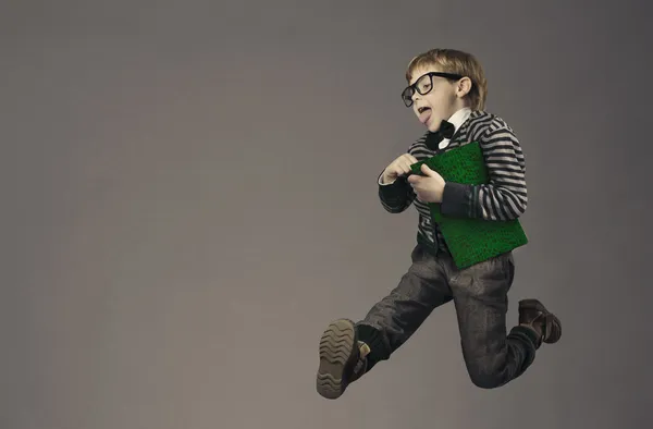 Çocuk koşarak geri okula, komik çocuk portre, gözlük ve kitap ile akıllı okul çocuğu atlama