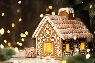 Noel Hediyesi Parlayan Çelenk Işıkları Altında Zencefilli Ev. Xmas Tatil Sanat Dekorasyonu. Dondurmalı tatlı zencefilli kek.