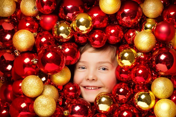 快乐微笑的孩子与圣诞球玩具 红白相间的孩子 明媚的圣诞树假日装饰 — 图库照片