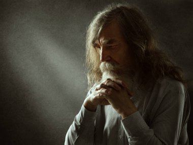 Yaşlı adam dua ediyor. Kederli Düşünen Yaşlı Beyaz Sakallı Aydınlık Işıklı Karanlık Arkaplan. İhtiyarlar Avuç İçleriyle Birlikte Yüze Tapar