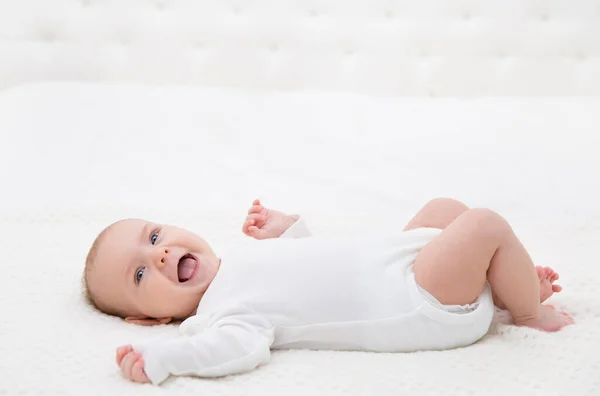 Happy Smiling Baby Lying Back White Bed Active Playful Baby — стоковое фото