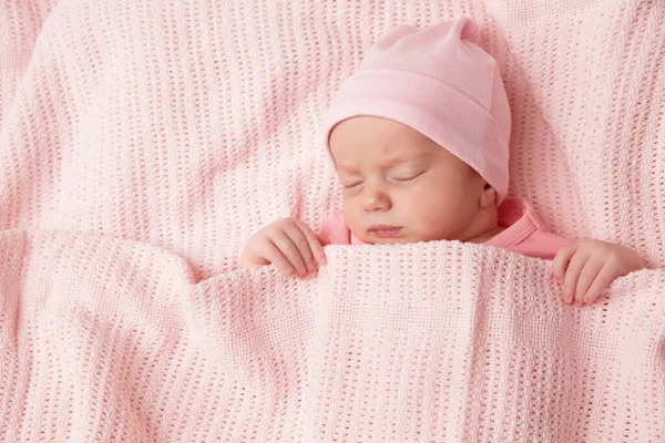 新生儿睡在针织毛毯下 可爱的婴儿裹在棉花毛巾里 新出生的小女孩穿着粉色衣服躺在床上休息 小孩儿脸肖像 — 图库照片