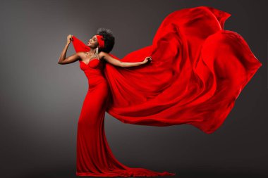 Rüzgarda uçan ipek eşarplı kırmızı elbiseli moda Afrikalı kadın. Mutlu Koyu Derili Model Kaygısız Dalgalanan Şifon Kumaşla Gri Arkaplan Üzerinde Dans Ediyor. Uzun Gece Şatafatlı Elbiseli Kıvırcık saçlı Şık Afro Kadın
