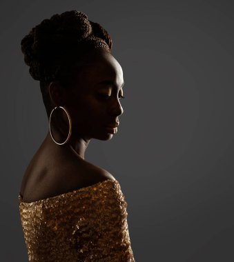 Afrikalı Kadın Yüz Profili Siyah Siluet. Altın Yüzük Küpeli Koyu Deri Güzellik Modeli ve Gri Arkaplan Üzerindeki Parlak Altın Elbise Saçlı Afro Saç Tarzı
