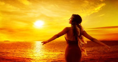 Woman enjoying Sunset. Women Rear View Silhouette Arms Outstretched looking away at Sea, Sun. Spiritual Relaxation and Meditation. Mystery Girl Dreaming over Sky Background