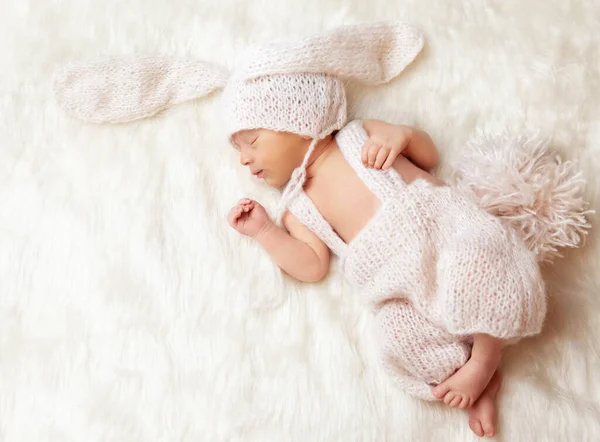 可爱的新生儿睡在毛毯上 兔宝宝与耳朵一起出生 穿着针织兔子衣的婴儿 儿童出生和照料 孩子们暖和的羊毛衫 — 图库照片