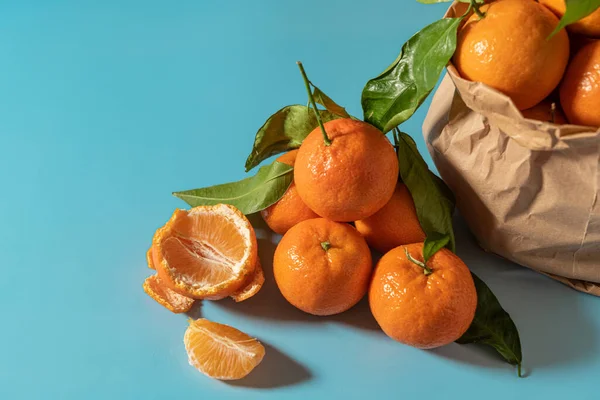 Sac Papier Avec Mandarines Fraîchement Cueillies Sur Une Surface Bleue — Photo