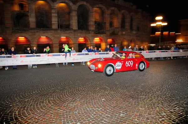 Um Ermini vermelho 1100 Berlinetta dirige antes da Arena di Verona durante a corrida de carros clássicos 1000 Miglia em 15 de maio de 2014 em Verona. Este carro foi construído em 1950 — Fotografia de Stock