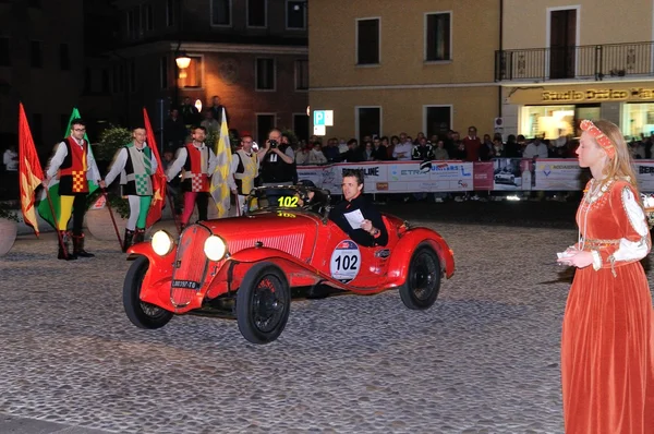 A red Fiat 508 CS Balilla sport takes part to the 1000 Miglia classic car race on May 15, 2014 in Marostica. The car was built in 1935. Flag wavers and other characters stand by — Stock Photo, Image