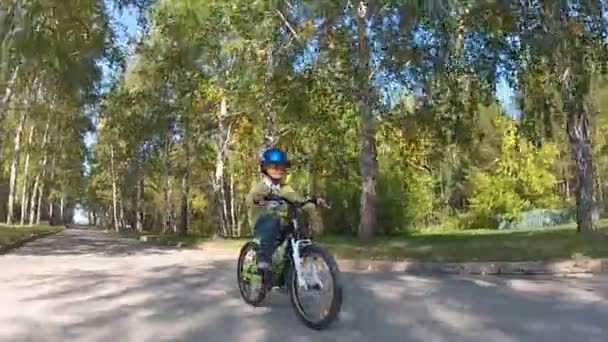 Jovem menino andar de bicicleta em um dia de outono — Vídeo de Stock