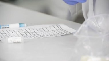 laboratuar asistanı test tüpleri ile biyolojik malzeme araştırma için hazırlar.