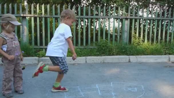 Irmão mais velho ensina júnior a jogar hopscotch — Vídeo de Stock
