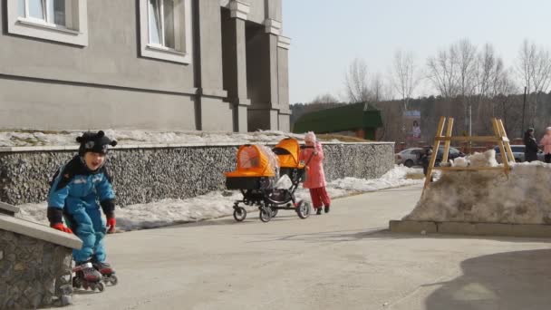 Junge lernt Rollschuhlaufen auf dem Spielplatz — Stockvideo