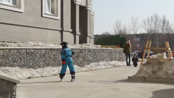 Pojke lär sig att roller skate på lekplatsen — Stockvideo