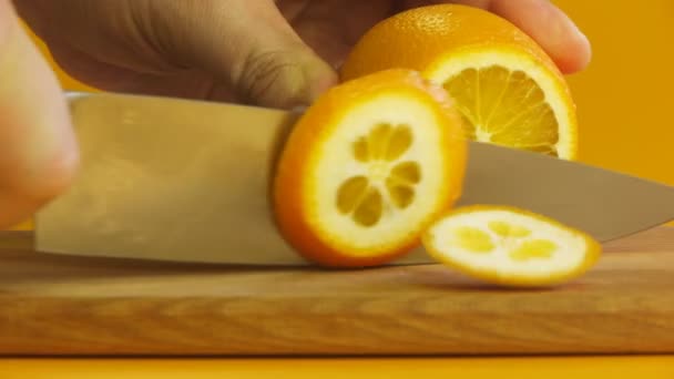 La mano del hombre en rodajas de naranja en el primer plano de tabla de cortar — Vídeos de Stock