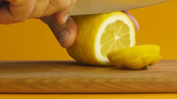 Мужская рука нарезала лимон на мелкой доске крупным планом — стоковое видео
