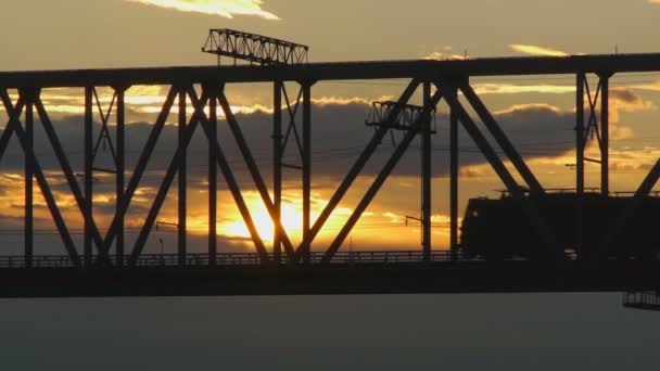 Paseos en tren de mercancías en el puente ferroviario al atardecer — Vídeos de Stock