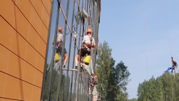 Modern byggnad under uppförande. byggare på byggnadsställningen. Novosibirsk, Ryssland. — Stockvideo