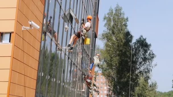 Modern byggnad under uppförande. byggare på byggnadsställningen. Novosibirsk, Ryssland. — Stockvideo