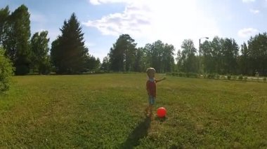 Küçük çocuk topla oynuyor.