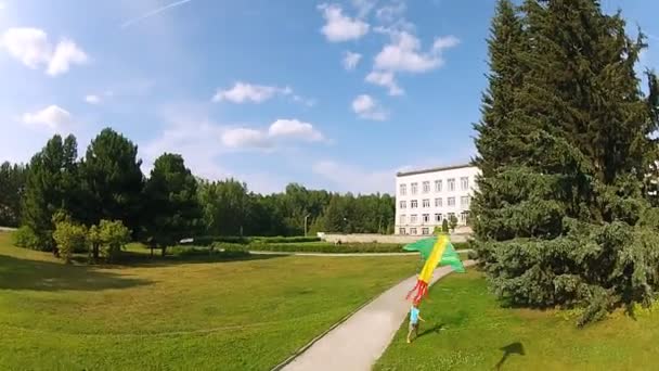 Garçon courant avec un cerf-volant dans le parc 
