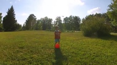 Küçük çocuk topla oynuyor.